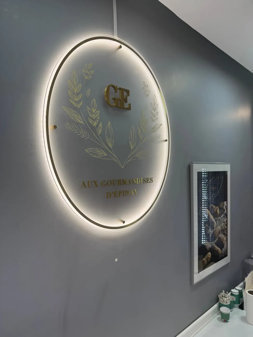 Logo lumineux Aux Gourmandises d’Épinay, cercle LED et lettres en laiton, Épinay-sur-Orge, par LADONNA