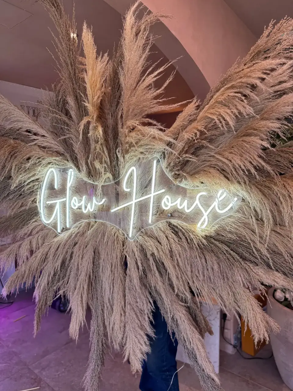 Néon blanc Glow House en écriture manuscrite au cœur d’une arche de pampas, institut à Bessancourt, par LADONNA